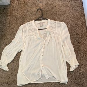 White blouse buttons down the front and ties in the back